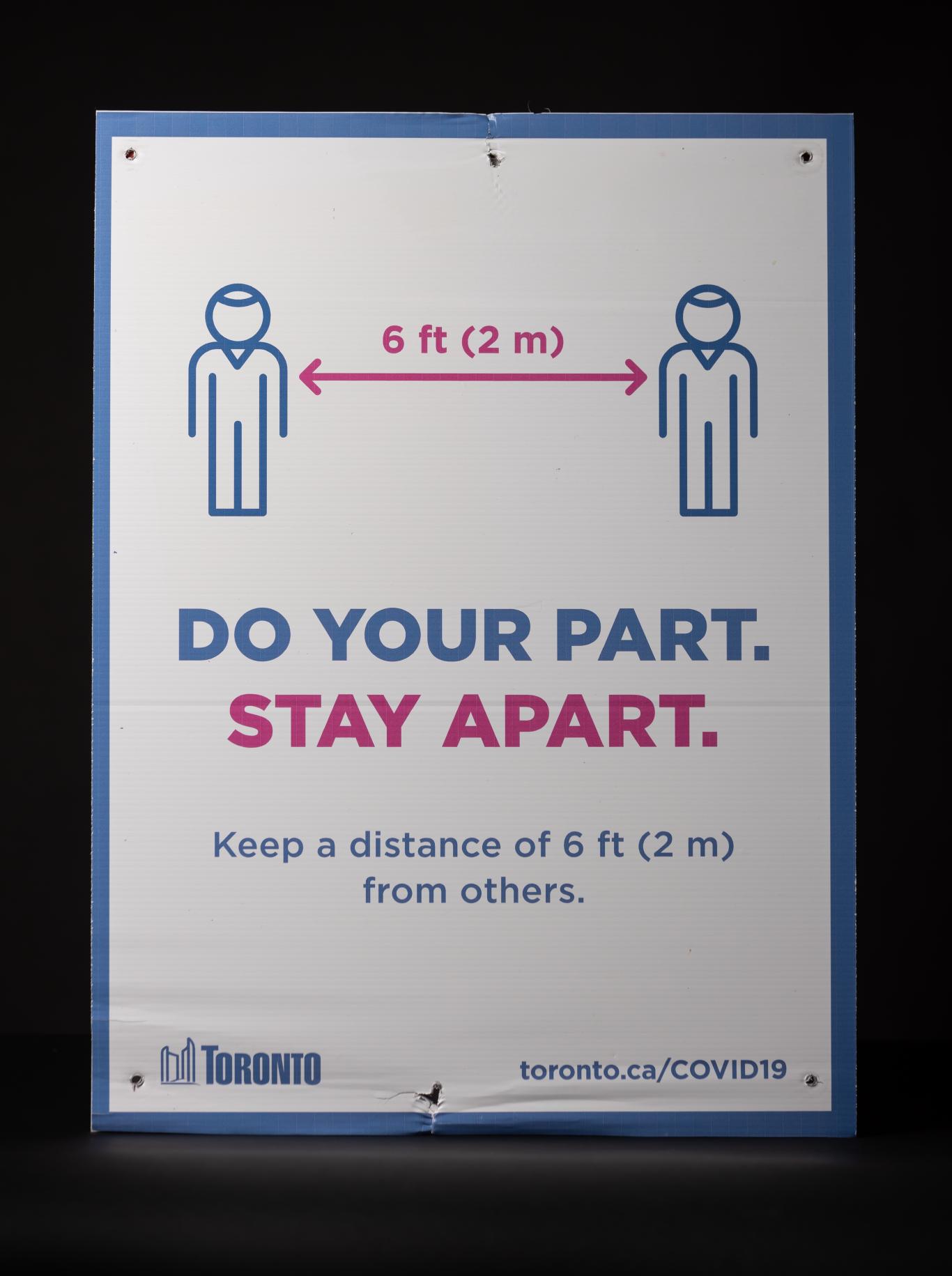 A vertical sign demonstrating how to keep a safe distance from another person.