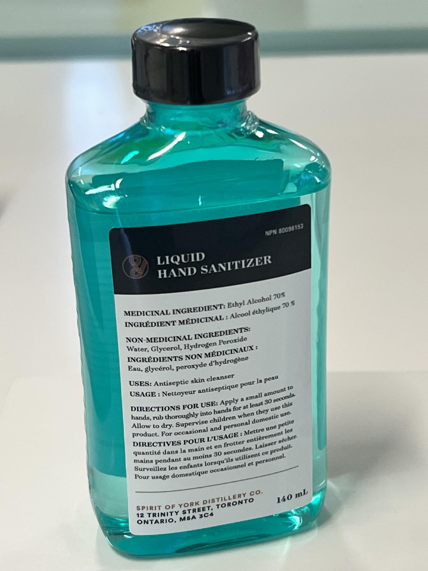 A bottle of light blue hand sanitizer.